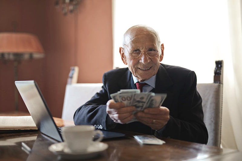 Old man counting money on his desk