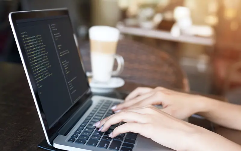 Young woman writing java script code for creating website