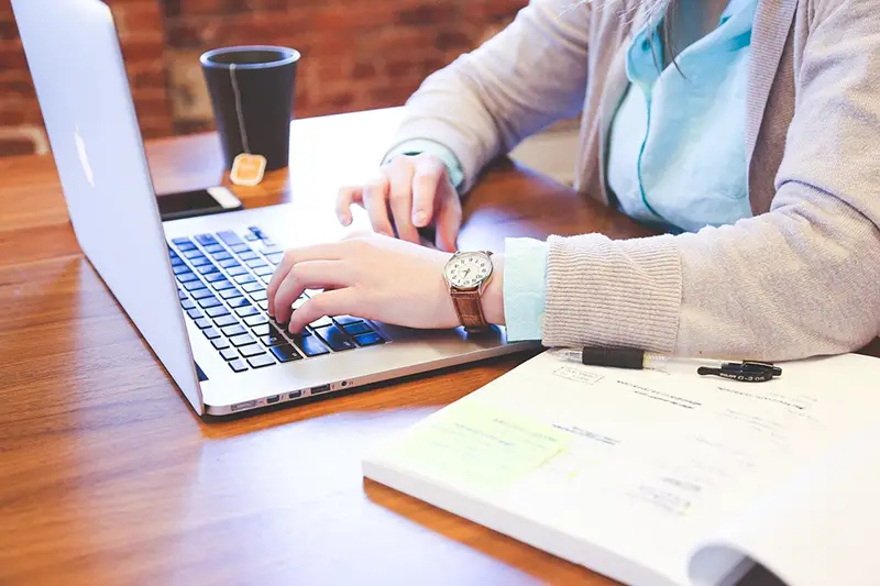 person working on macbook sitting at a desk