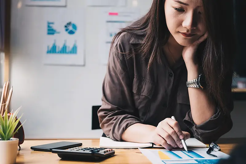 Businesswoman working on her desk near calculator