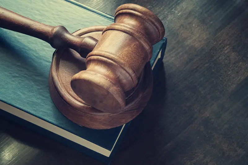 Judge gavel and legal book on wooden table