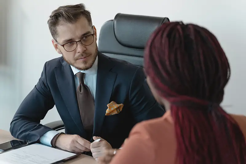 Man in black suit interviewing a woman applicant