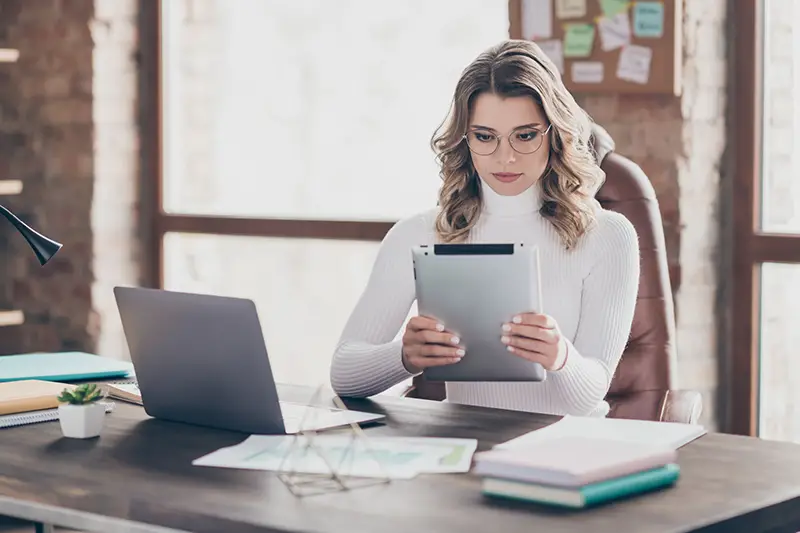 Young female marketer using her Ipad in front of her desk