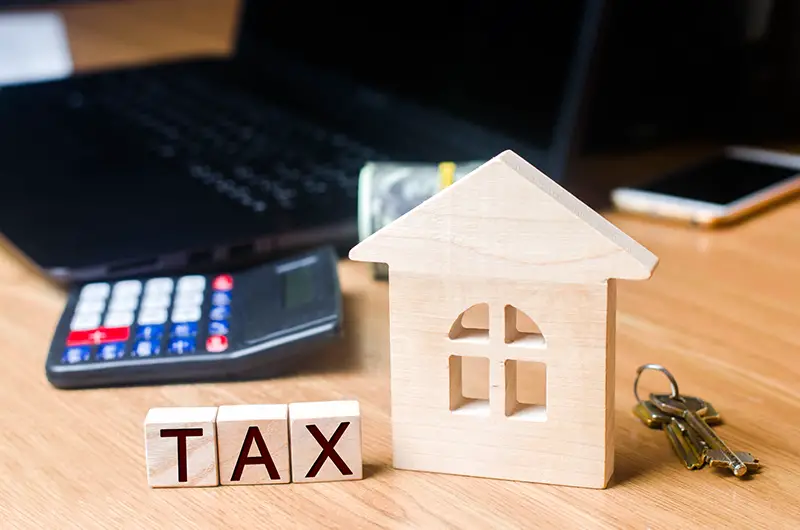 Small Wooden house and taxes on the desktop