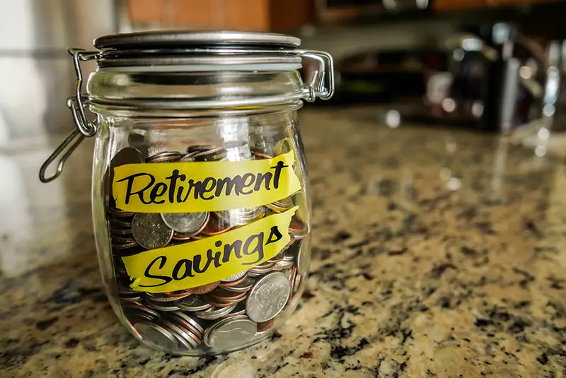 Retirement savings coins in a glass jar
