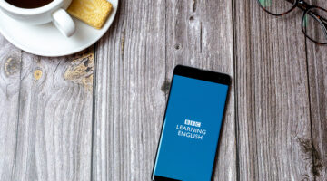 Cell phone on a wooden table with the BBC Learning English app open
