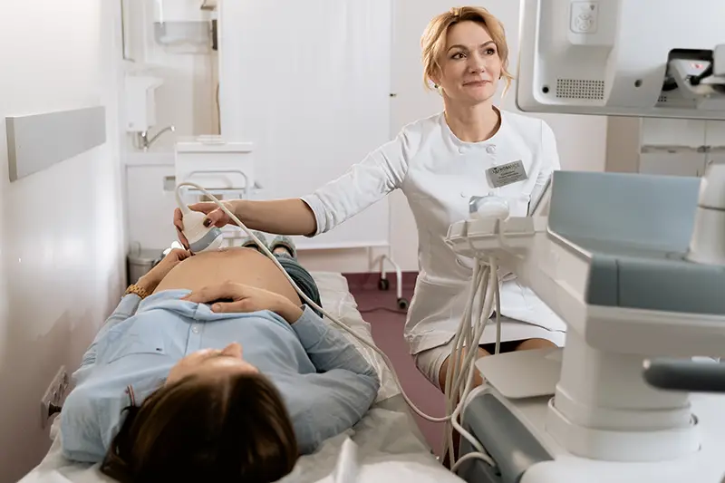 photo of gynecologist doing ultrasound to a pregnant woman