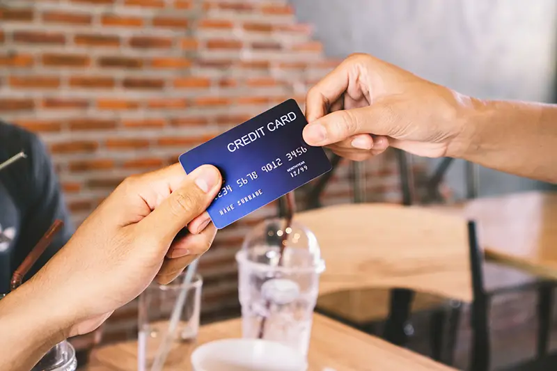 Man hand paying his drinks by credit card in coffee shop
