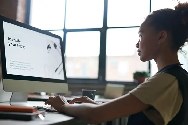 Young woman working in front of Macbook computer