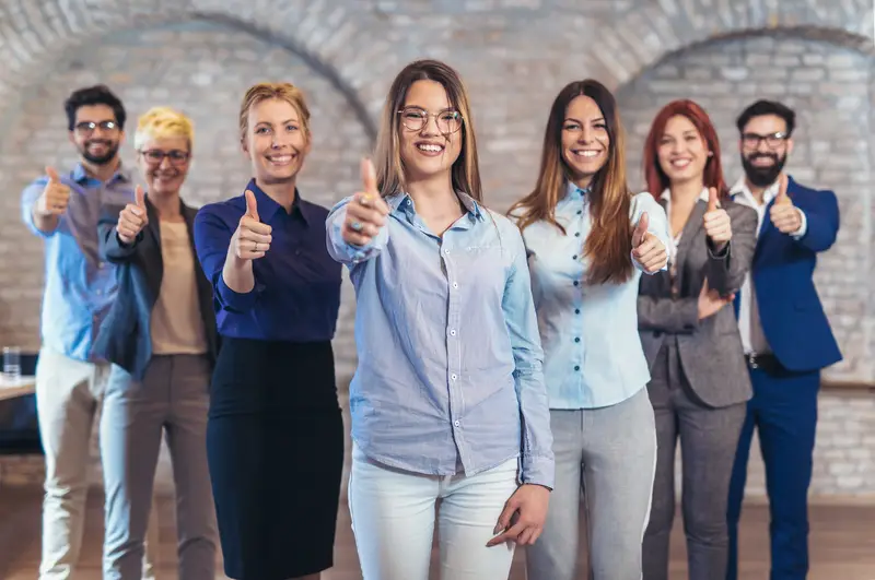 group of employees facing in front while doing thumbs up