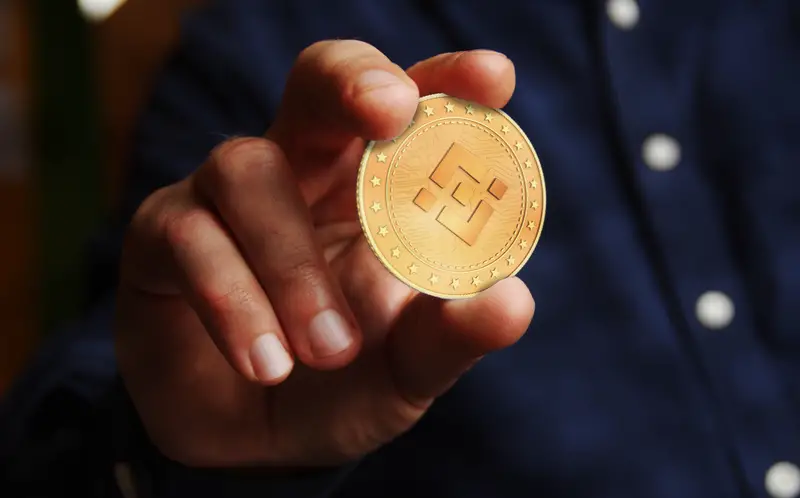 Binance BNB cryptocurrency symbol golden coin in hand abstract concept