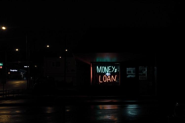 night scene with neon lights signage of money and loan