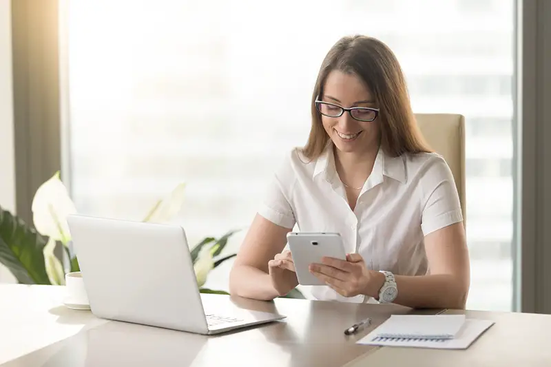 Woman smiling while using her mobile phone