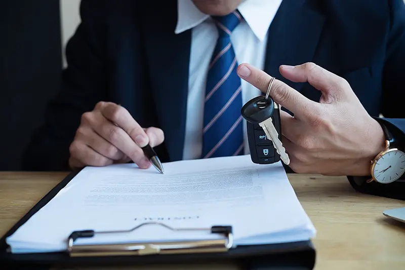 Person signing a car loan agreement