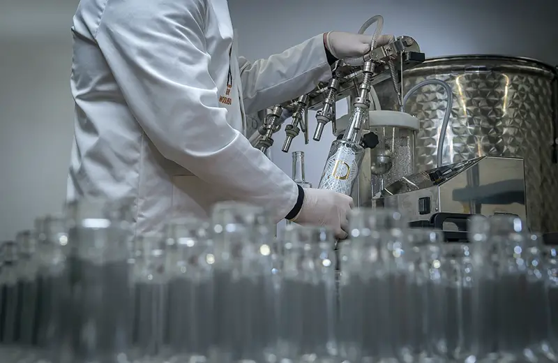 person refilling the empty clear bottles