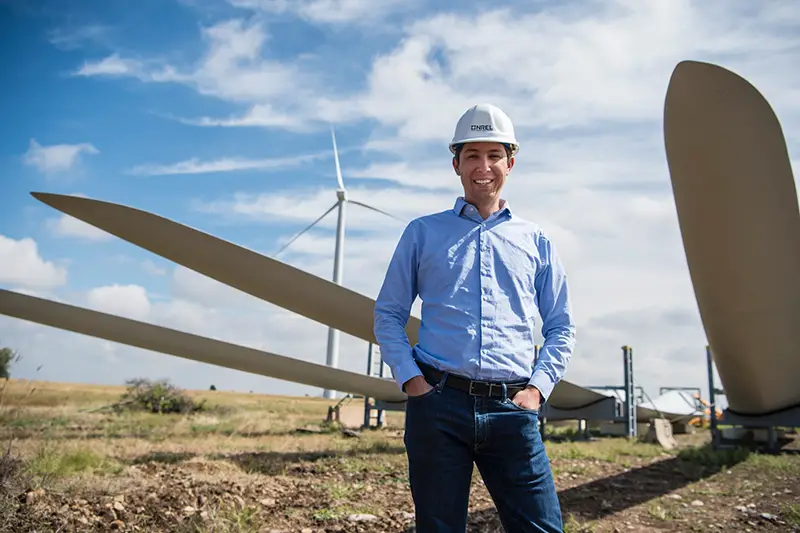 Civil engineer standing near windmill