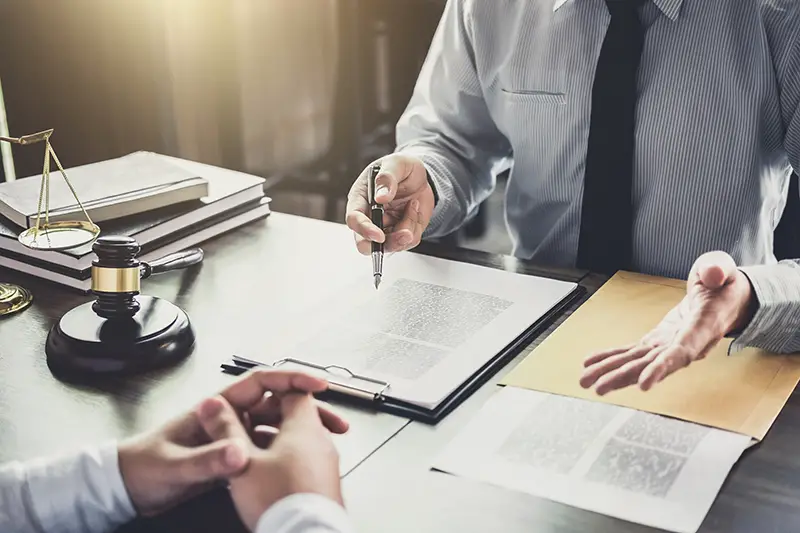 Lawyer signing a contract in front of his client