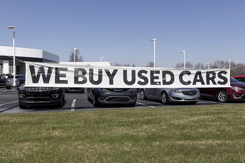 We buy used cars signage on the parking lot