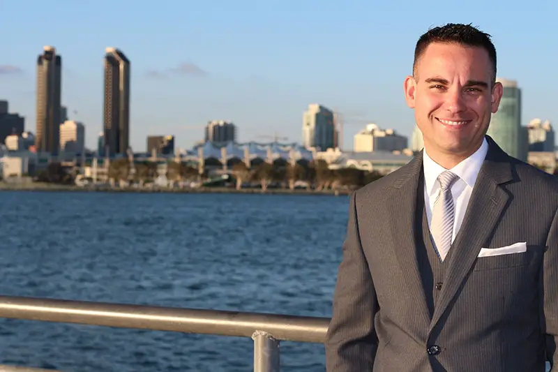 Businessman standing background of water and buildings