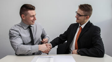 two men facing each other while shaking hands