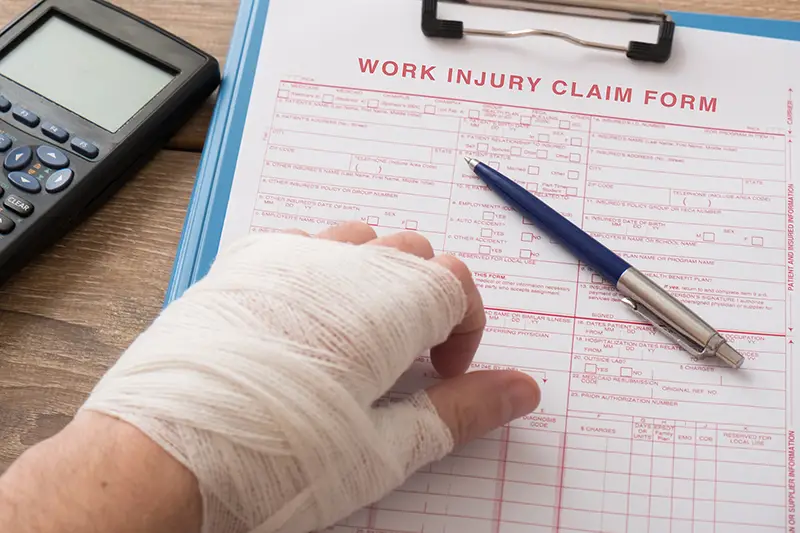 Person with hand injured filing work injury claim form
