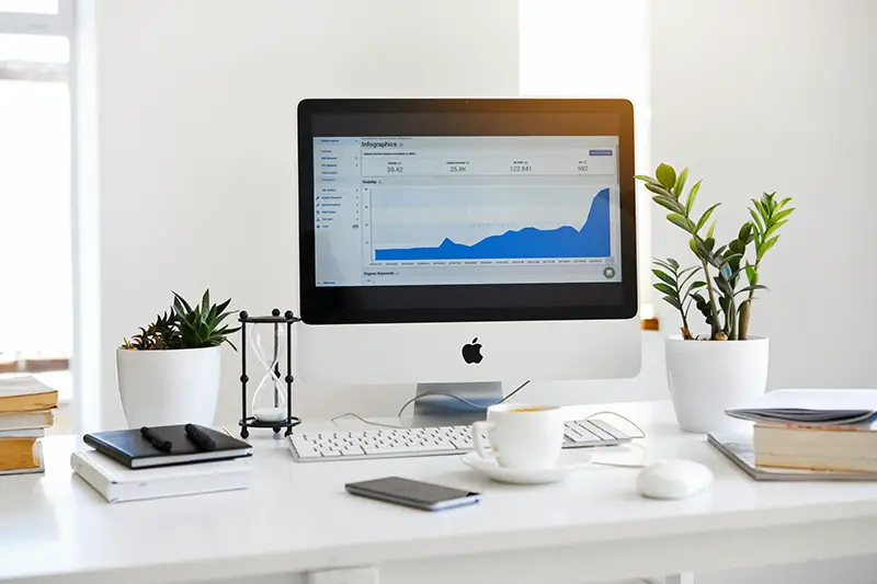 Silver Imac displaying line graph placed on desk