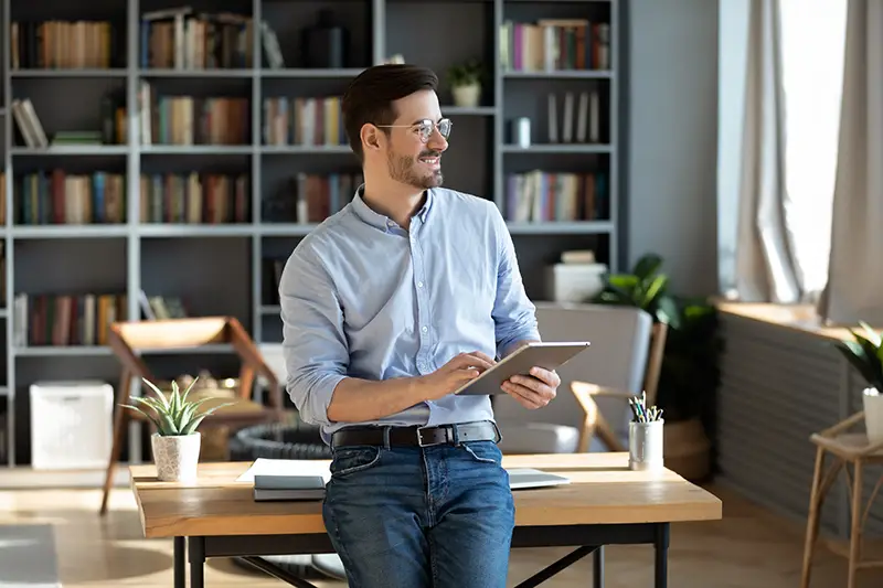 Young businessman smiling while holding his ipad