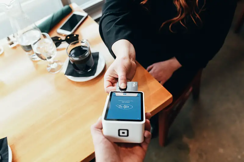 Person paying in a restaurant using her credit card