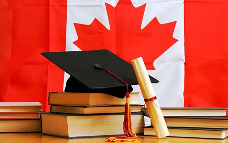 Books and mortarboard hat with Canadian flag on background