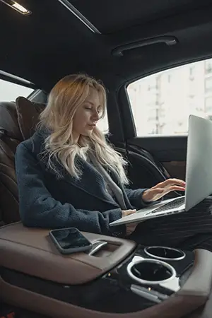 Woman In Gray Business Suit Sitting At  the back seat of luxurious car