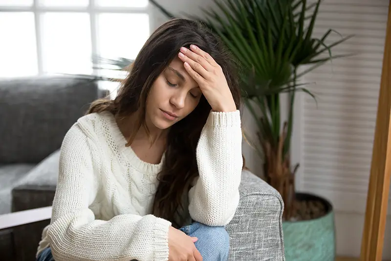 Stressed woman sitting in the couch