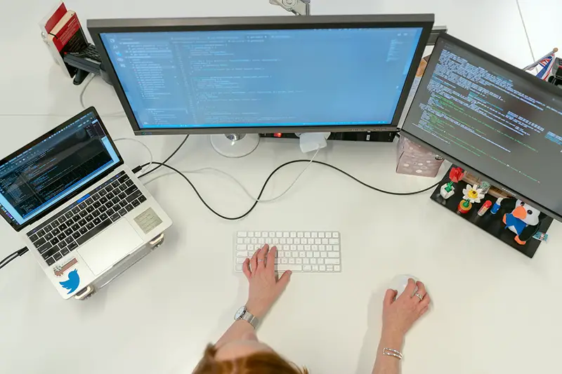 Female software engineer coding on computer