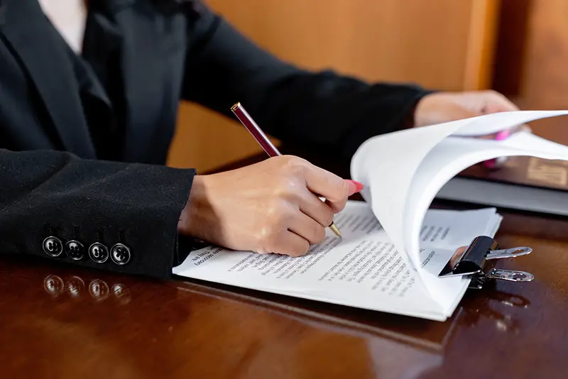 Man in black suit signing a documents