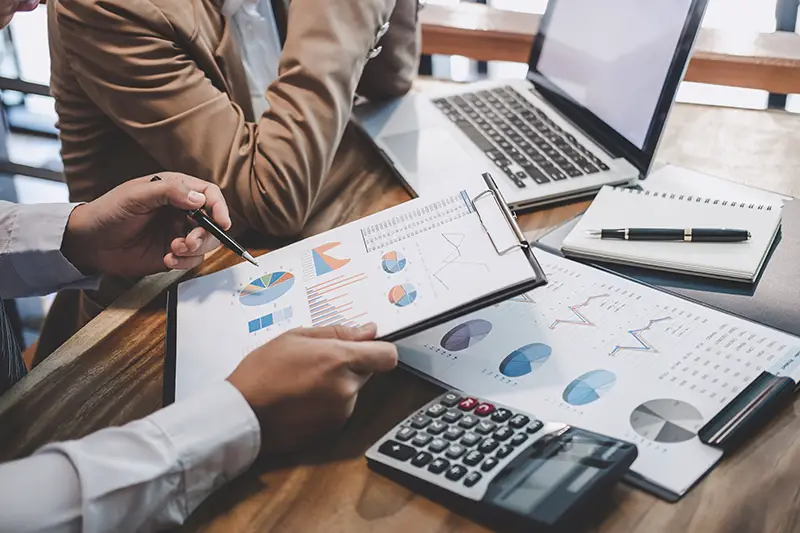 Person holding clipboard with graphs and data on white paper