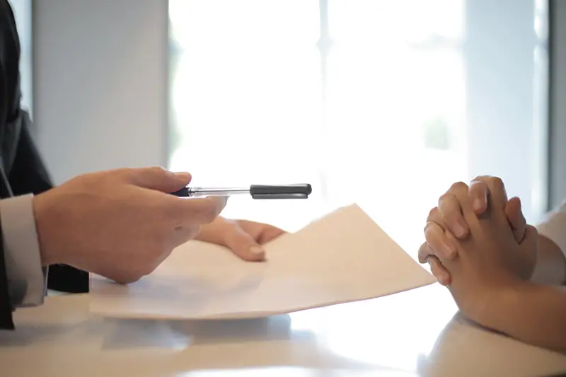 Businessman giving contract to a woman to sign