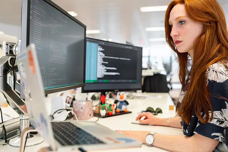 Woman working in front of two computer screen