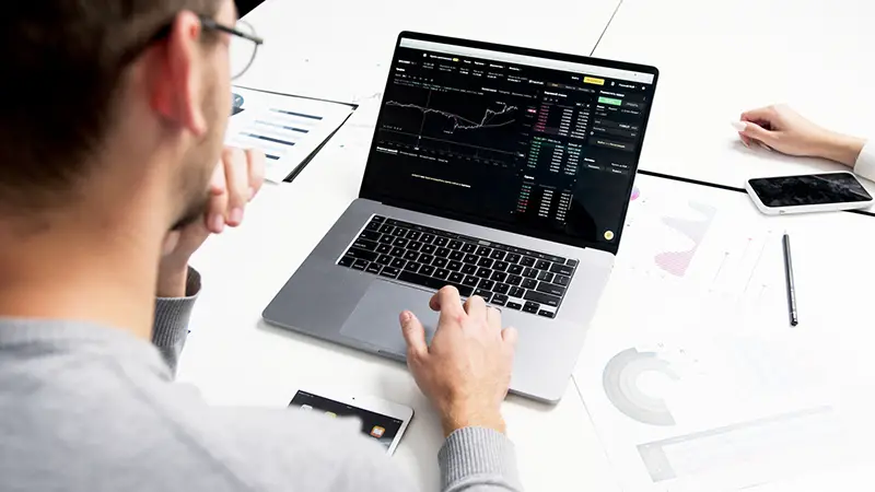 Person using macbook Pro on white table