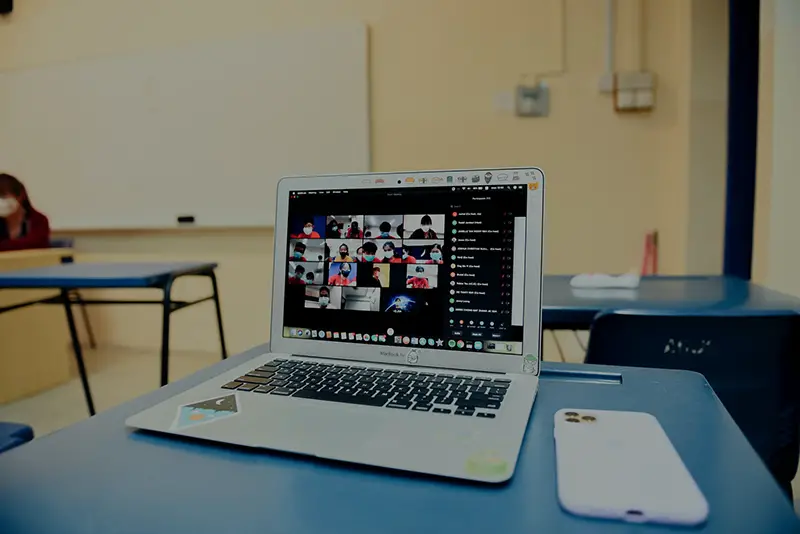 MacBook pro on table with people on virtual meetings