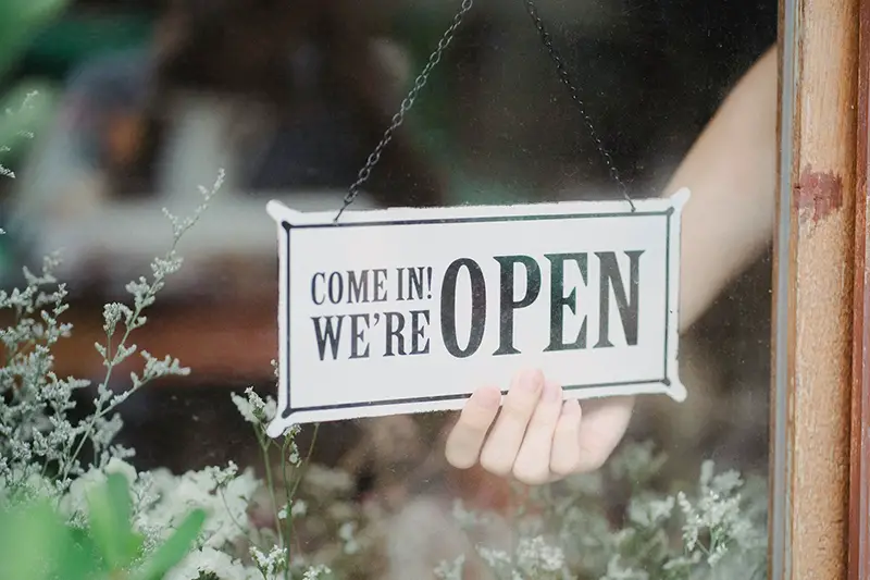 Crop person showing signboard on window