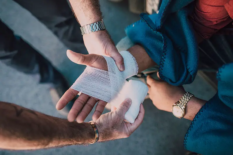 person applying bandage on another person's arm