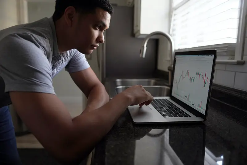 Man in gray shirt in front of his laptop