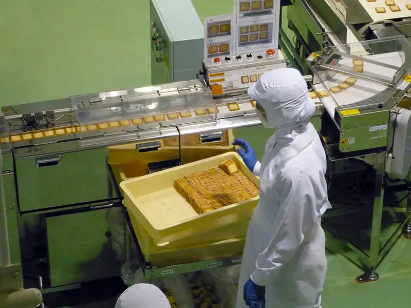 Person wearing white jumpsuit inside the Manufacturing plant