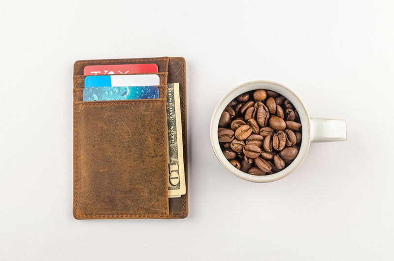 Brown leather wallet beside the white mug with coffee bean