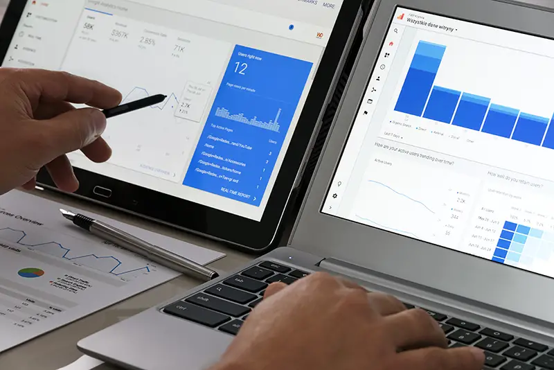 Person using laptop with graphs and analytics on the screen