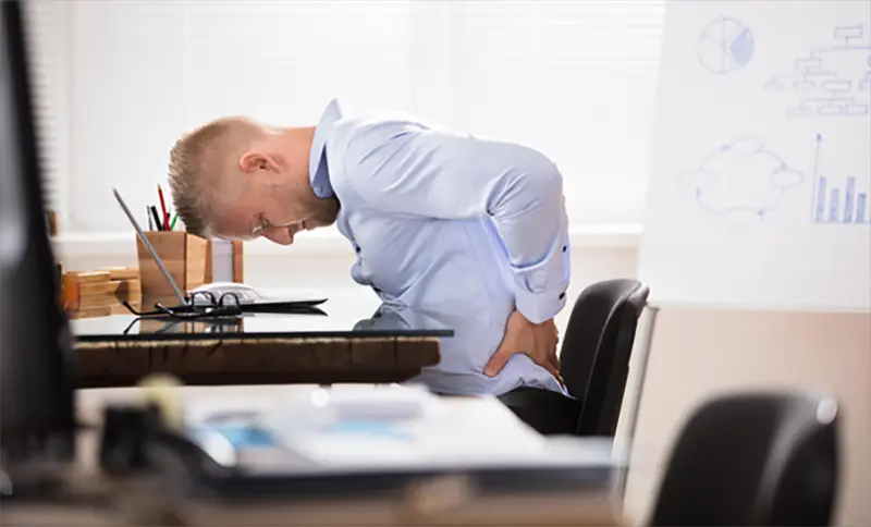 Man sitting in the office suffering backpain