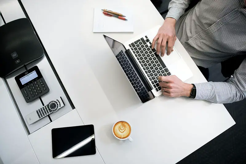 Man in stripe long sleeves working in front of his laptop