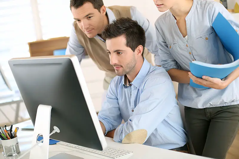 Workteam in office working on desktop computer