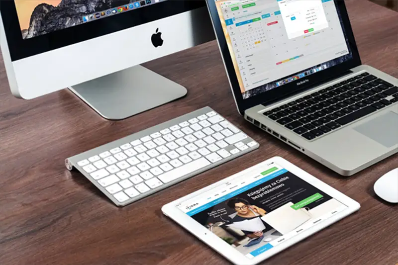 Laptop and Ipad on top of wooden table