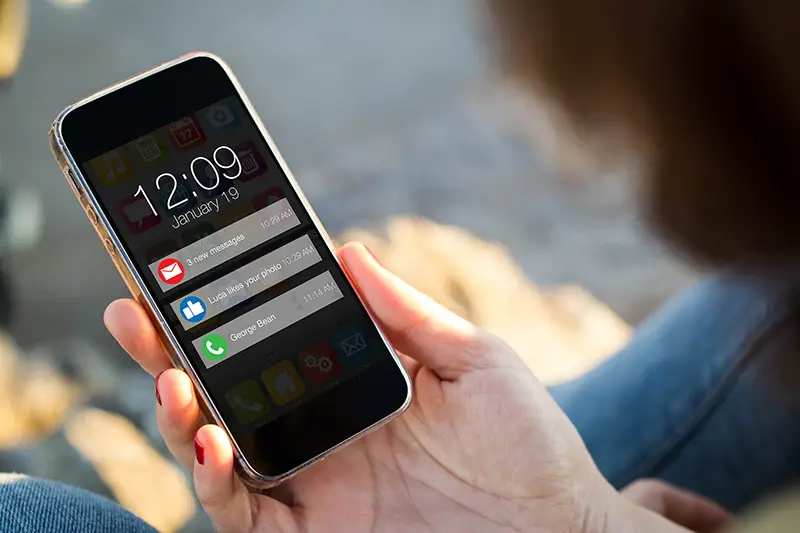 close-up view of young woman looking at notifications on her mobile phone.