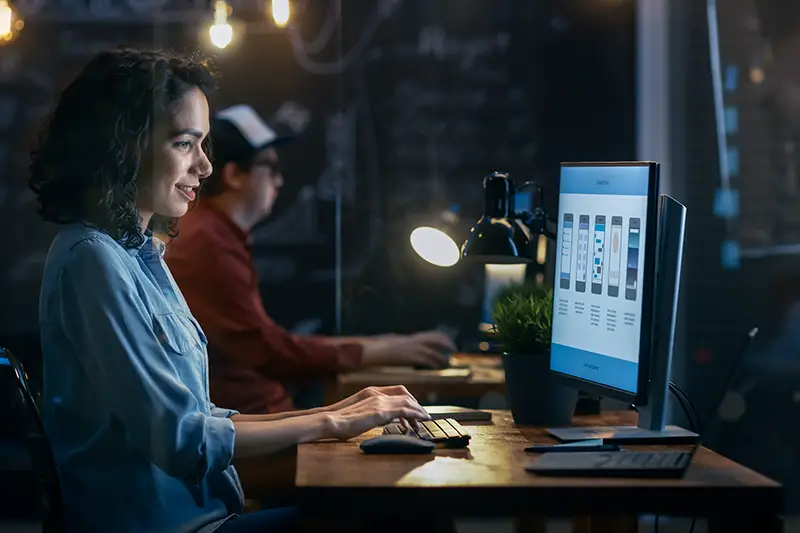 Female Coder Works at Her Desktop on Her Personal Computer